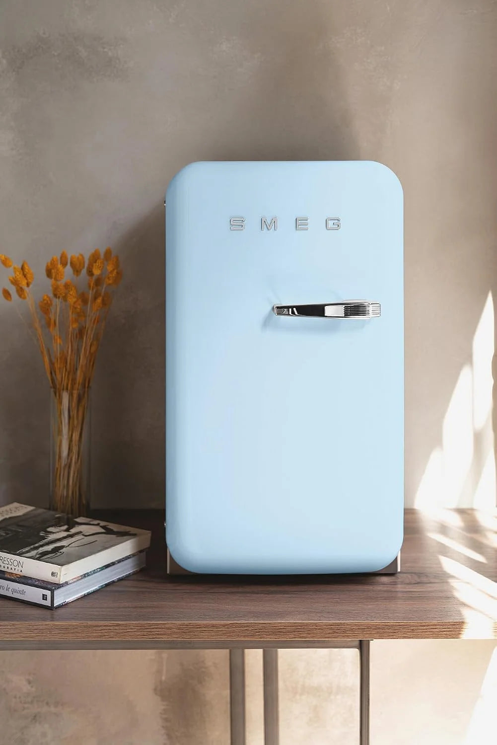 Minibar Smeg FAB5LDPB6, año 2026, estilo vintage, una puerta, 34 L, bisagra izquierda, refrigeración estática, 2 estantes ajustables, botellero e iluminación LED, altura 72,5 cm, azul celeste.