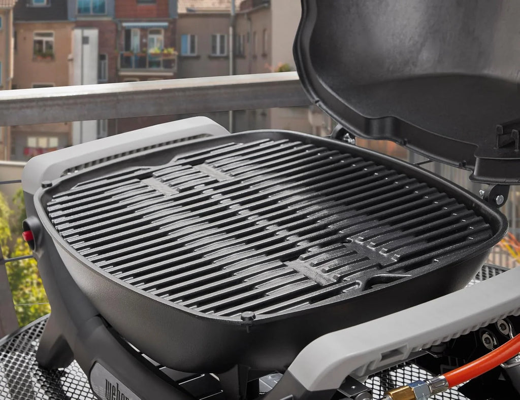 Parrilla de gas portátil Weber Q 1100N 2026, ligera, ideal para acampar, patios y balcones. Cuenta con quemador de alto rendimiento, rejillas de hierro fundido esmaltado y encendido electrónico. Color negro medianoche.