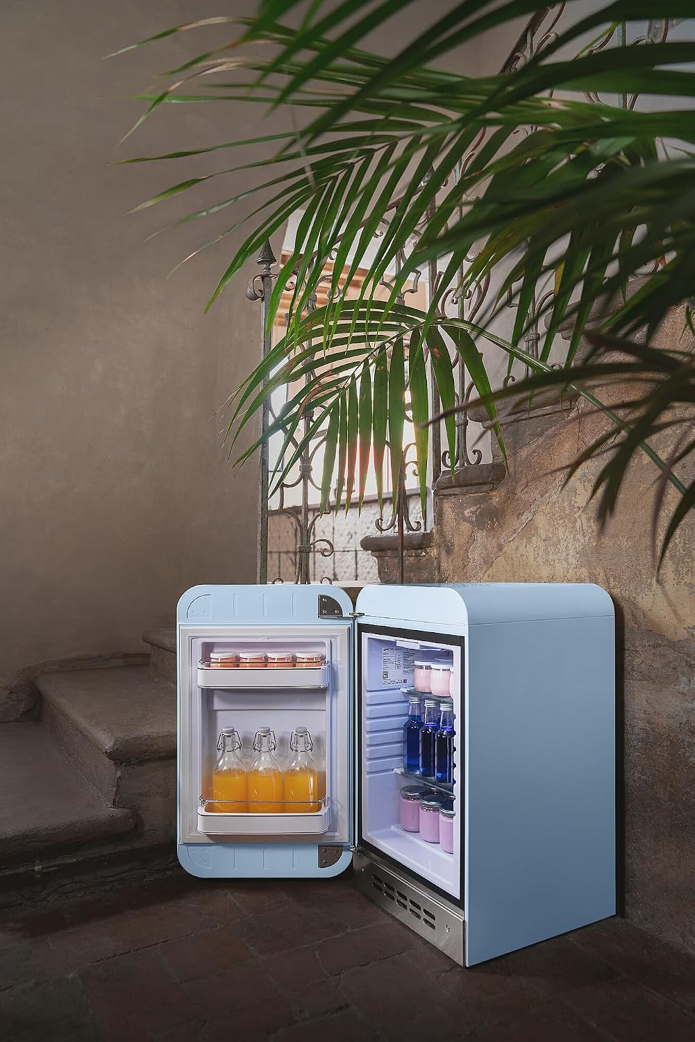 Minibar Smeg FAB5LDPB6, año 2026, estilo vintage, una puerta, 34 L, bisagra izquierda, refrigeración estática, 2 estantes ajustables, botellero e iluminación LED, altura 72,5 cm, azul celeste.